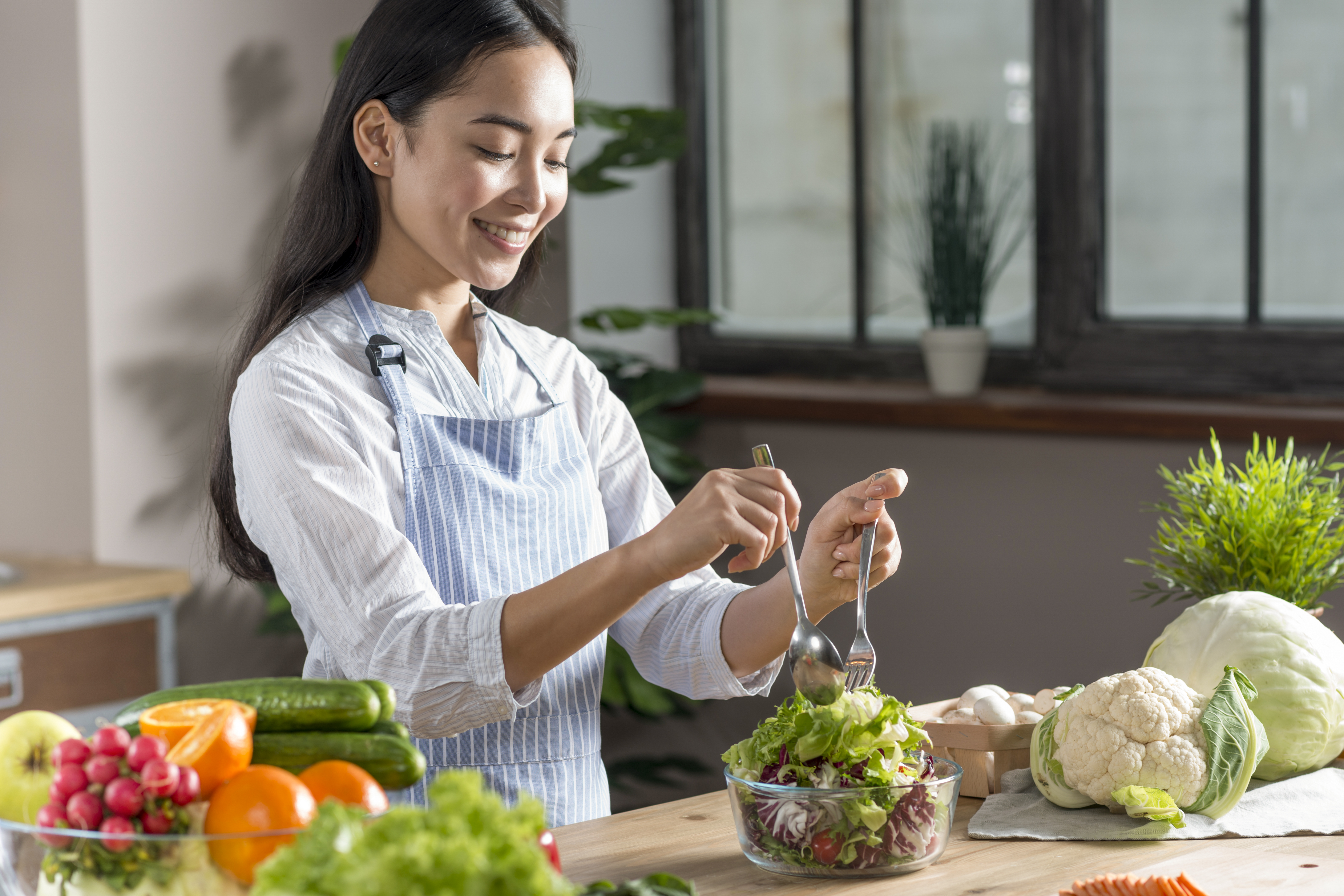 女生正在廚房吃著蔬菜水果，來補充膳食纖維